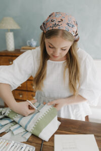 A woman cutting fabric in her studio.