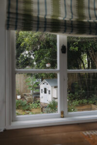 Looking out the window to a white cubby and garden area.