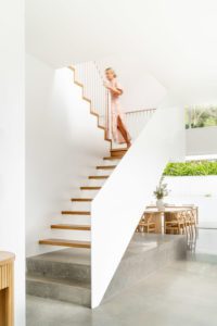 A homeowner walks up the stairs of her house.