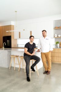 A meet the team shot with a builder and a town planner in the kitchen.