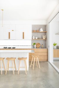 A modern kitchen with open shelving and timber cabinetry.