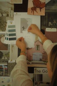 Hand placing quote onto a Inspiration Board and pinning it on.