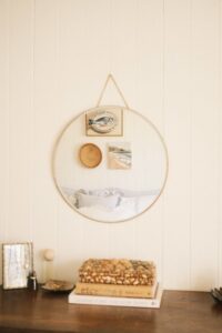 Primary bedroom of a country style Queenslander home displayed in the reflection of a circular mirror.