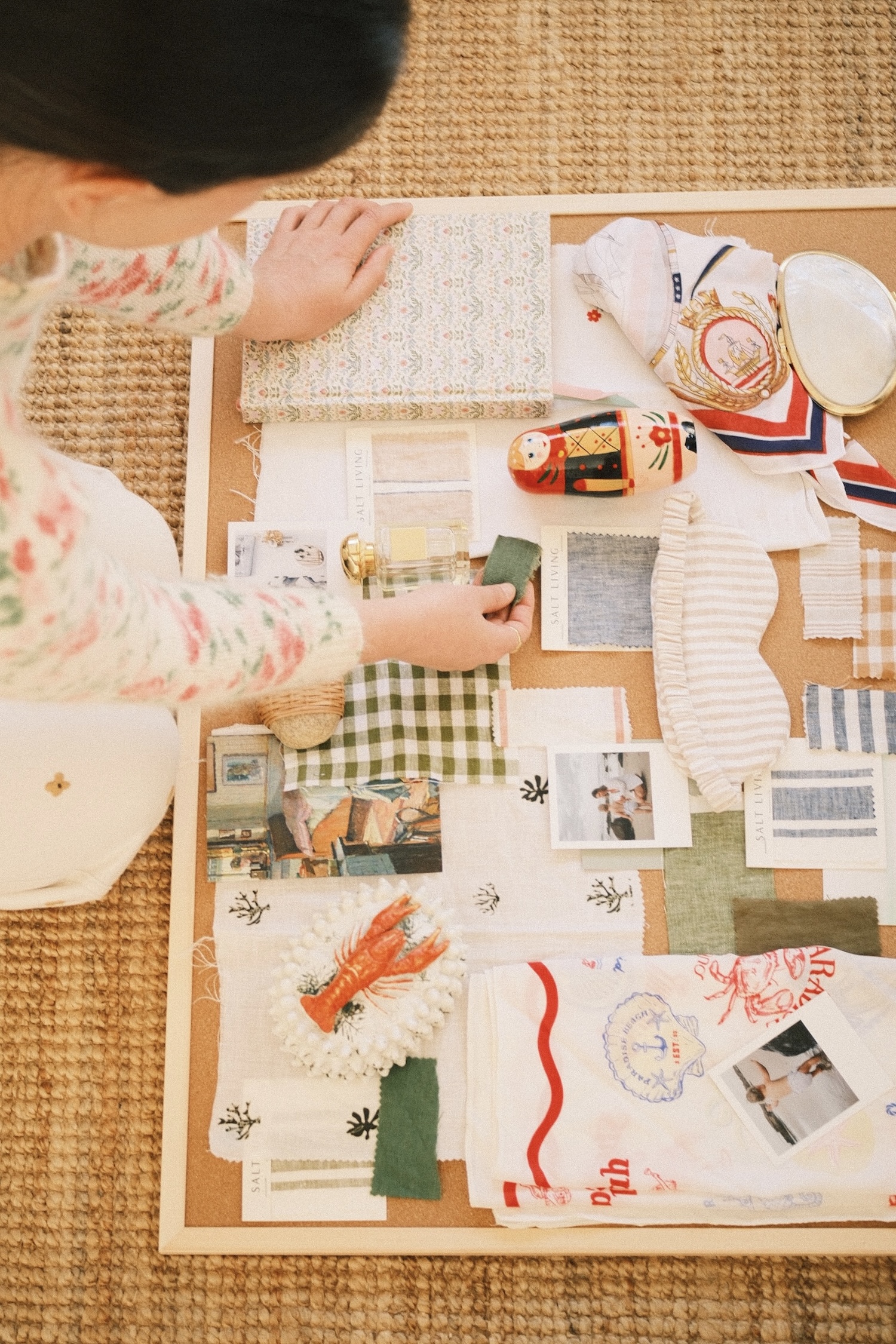 Shot of a curated mood board with a lady's hand adding a swatch.