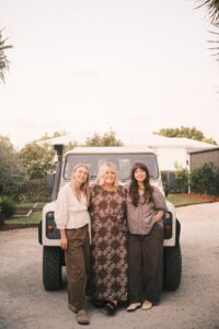 The studio team stand together in front of a white 80's Defender.