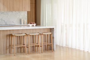 Modern stone and timber kitchen with kitchen bar stools under the counter.