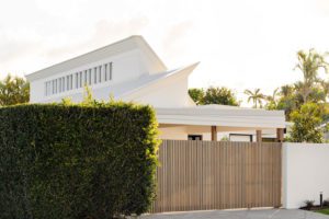Pitched roofline of a white house facade.