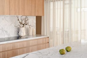 A modern kitchen featuring a stone bench top.