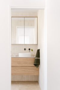 A modern and natural bathroom with a khaki Baina hand towel.