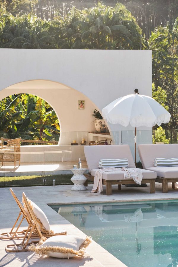 Arch pool house behind a modern pool.