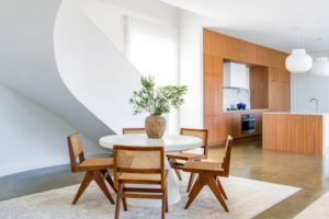 Walnut chairs and concrete dining table with a walnut kitchen.