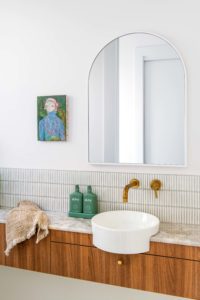 An arch mirror in a modern powder room.