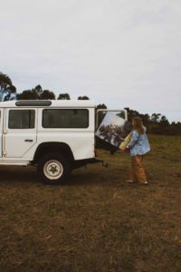 Artist unloads artwork from the back of a Defender Land Rover.