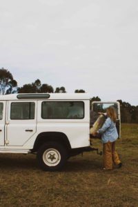Artist unloads artwork from the back of a Defender Land Rover.