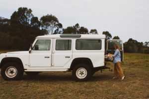 Artist unloads artwork from the back of a Defender Land Rover.