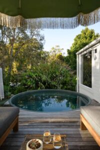 Shot from the sun lounges on a deck overlooking a circular plunge pool.