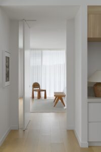 A view from outside the primary suite looking into the room with a Rachel Donath chair in the corner.