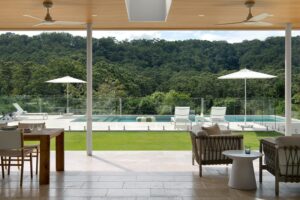 A modern Palm Springs inspired outdoor and pool area, looking out to forest views.
