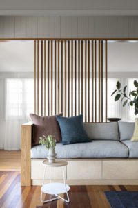 A modern custom lounge with grey, navy and burgundy cushions.