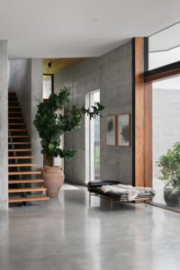 A modern bedroom with concrete floors and walls.
