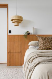 A natural style modern bedroom with a custom built bedhead.