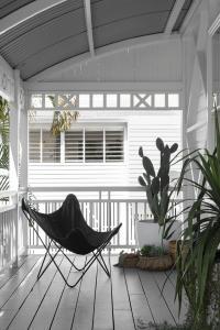 The verandah of a Queenslander home with a black butterfly chair.