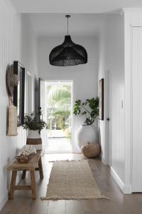 A black pendant hangs down in the entrance of a Queenslander renovation.