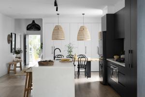 A kitchen and dining room. Two lights hang from the ceiling.