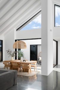 Modern dining room with an elmwood table and rattan dining chairs.
