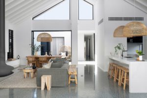 A hanging fireplace and grey lounge are pictured in a modern living room.