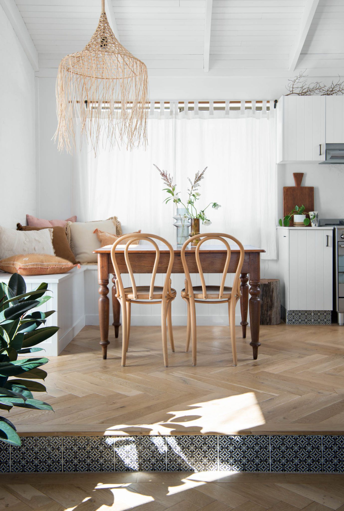 A vintage wooden dining table, bentwood chairs, and VJ bench seats.