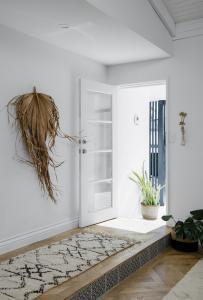 A Moroccan rug lines the floor at the front door of a beach house.