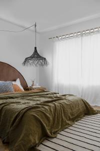 A khaki bedroom with a Create Estate arch bedhead.