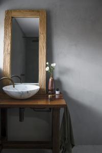 A timber mirror in a bathroom rest above a vanity.