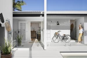 A homeowner stands in her doorway near a vintage look bike.