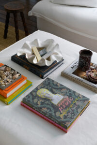 A view from above of a coffee table covered in books, candles and trinkets.