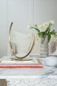 A marble coffee table is decorated with books and objects.