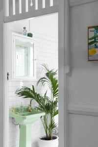 A green vintage vanity and palm decorate an art deco apartment.