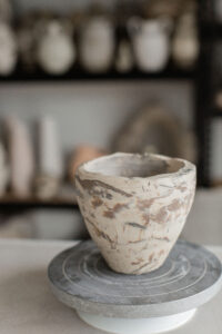 A work in progress from the home studio of ceramic artist Nioka Clay. A marbled handbuilt vase sits half completed.