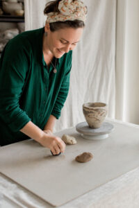 Ceramic artist Kerri of Nioka Clay works to build a vase in her home studio.