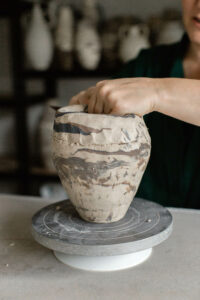 Ceramic artist Kerri of Nioka Clay works to build a vase in her home studio. A close up of the different clays coming together in a marbled pattern.