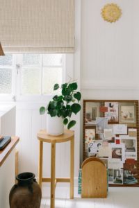 A corkboard leans up against a wall in a home office.
