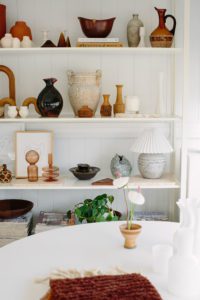 A shelf of vintage items are styled in an office.