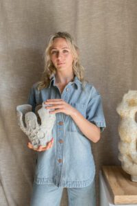 Tess Miller ceramic artist holding a sculpture.