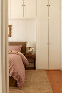 Long shot of a bed, styled with Pinot Gingham and Yellow Stripe bed linen.