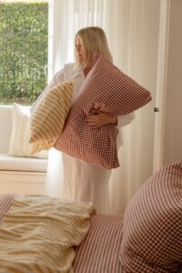 Stylist Hayley Jenkin midway through styling a bed for a shoot with Carlotta and Gee sheets and a Sleeping Giant bed.