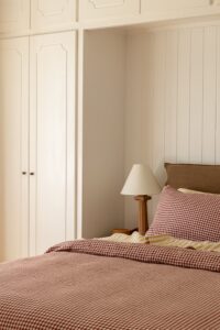 Close shot of a bed, styled with Pinot Gingham and Yellow Stripe bed linen.
