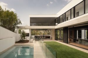 Exterior view of backyard and outside area with pool on left and house on right.