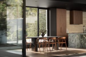A dining table with walnut chairs, looking back into the kitchen.