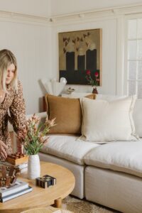 Hayley styles a coffee table in a lounge room for a shoot.